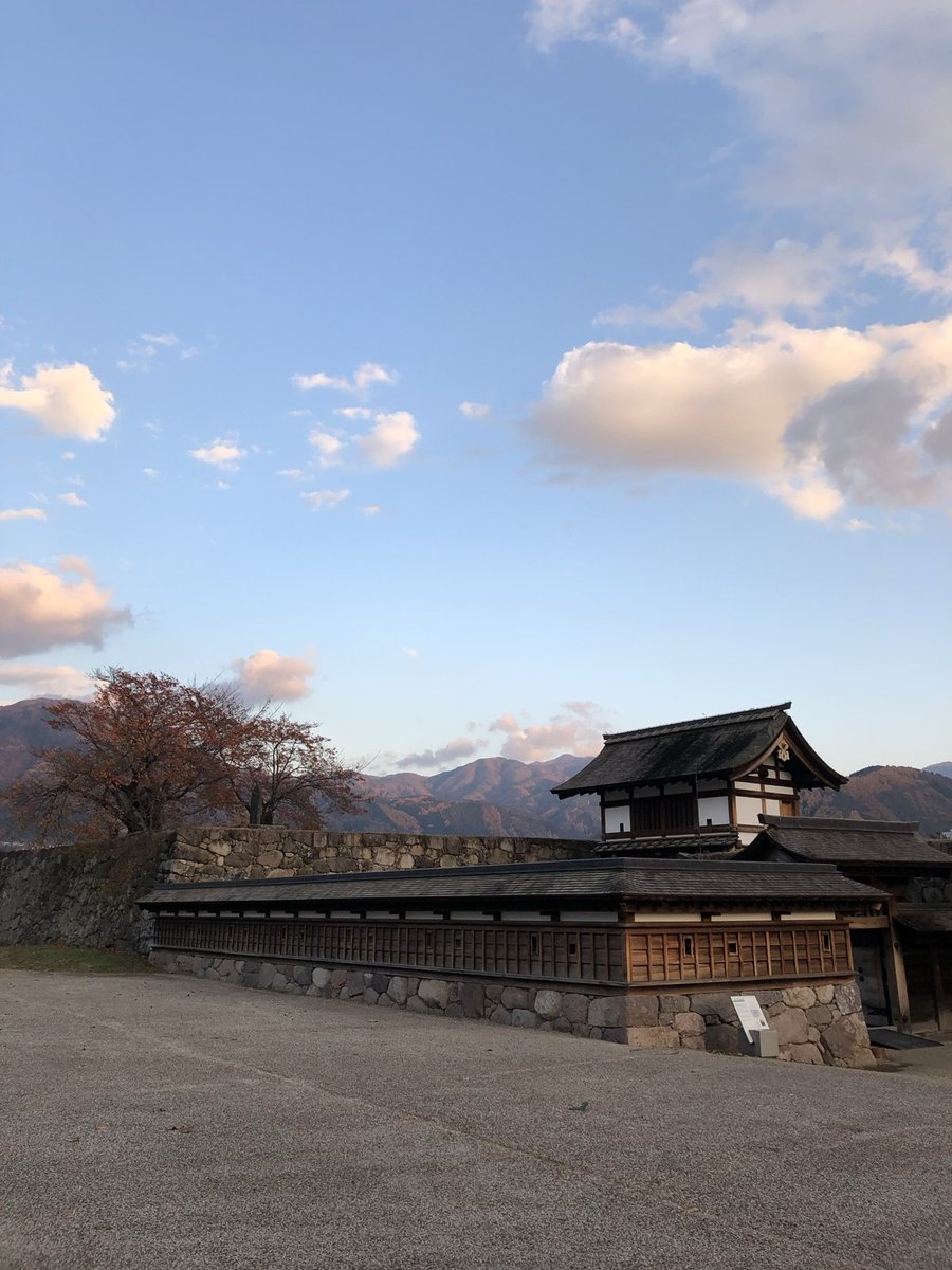 夕空に山並みが広がる松代城の復元された門と塀